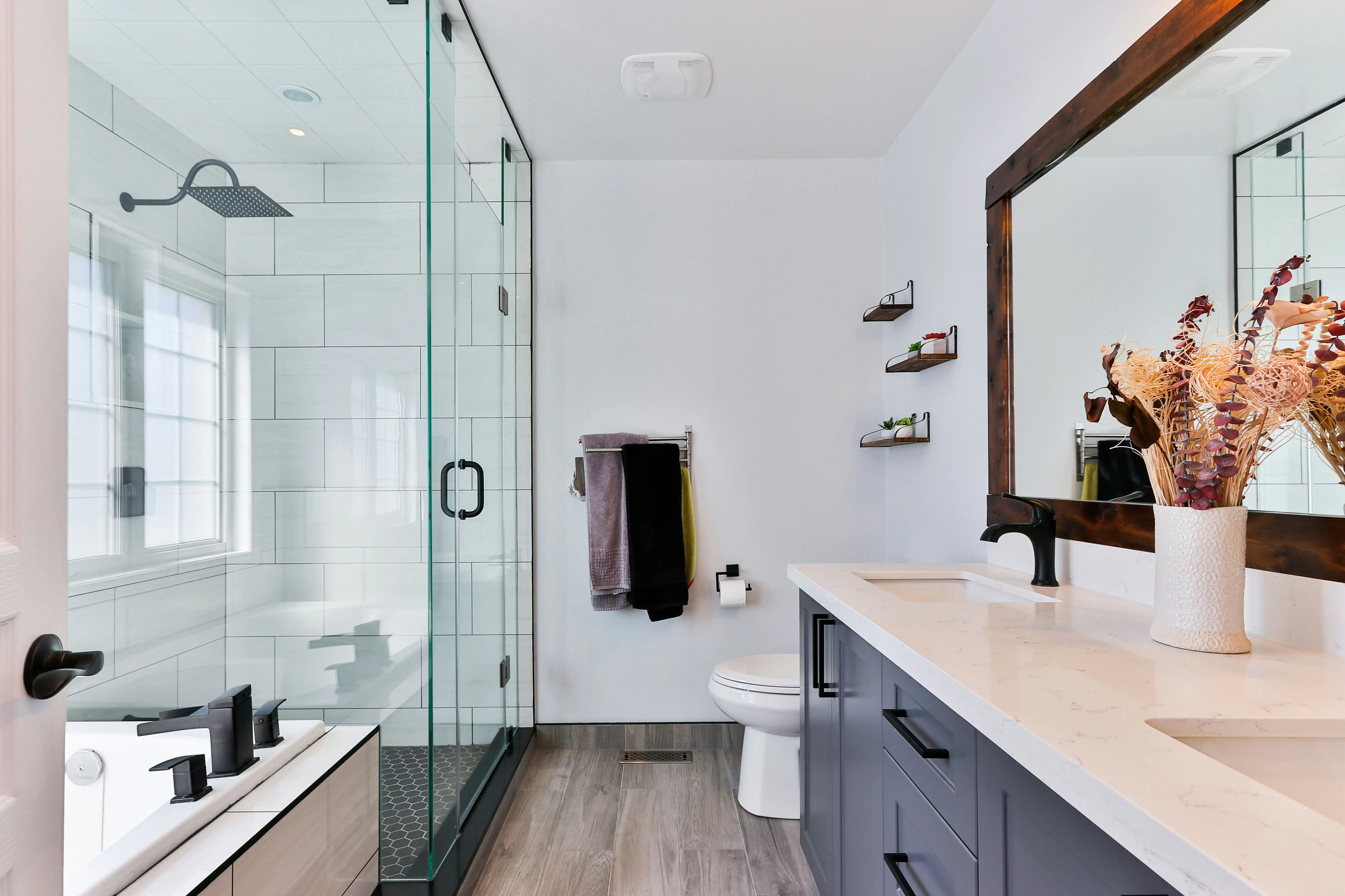 Bathroom with gray sink cabinets and a glass shower cubicle